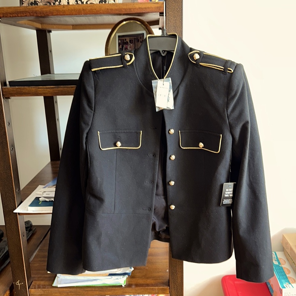 Military style lady’s jacket with gold trim and buttons on front and sleeves.